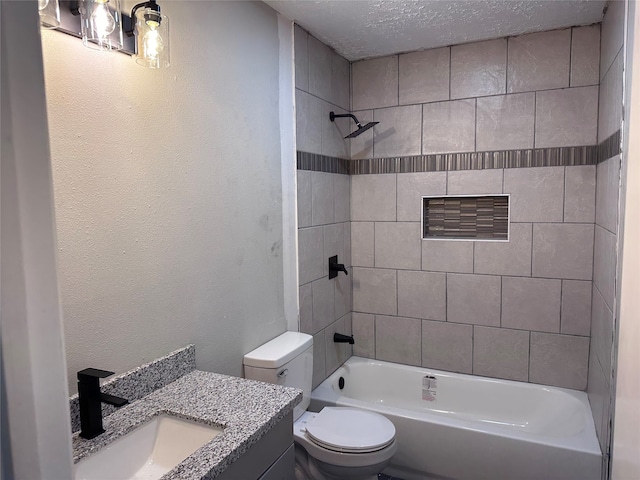 full bathroom with a textured ceiling, vanity, toilet, and tiled shower / bath combo