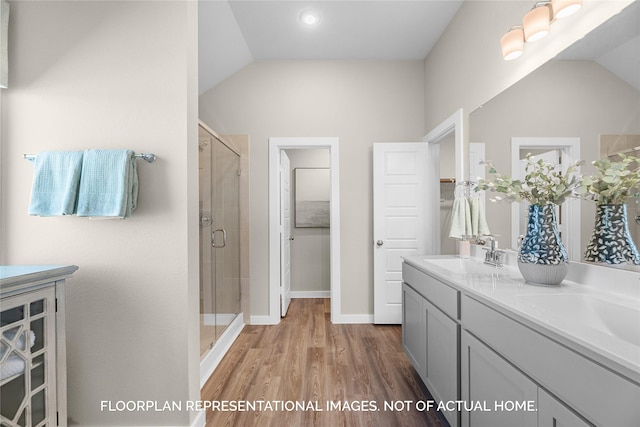 bathroom featuring hardwood / wood-style floors, vanity, lofted ceiling, and a shower with shower door