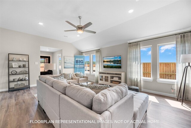 living room with hardwood / wood-style floors, vaulted ceiling, plenty of natural light, and ceiling fan