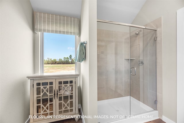 bathroom with walk in shower and lofted ceiling