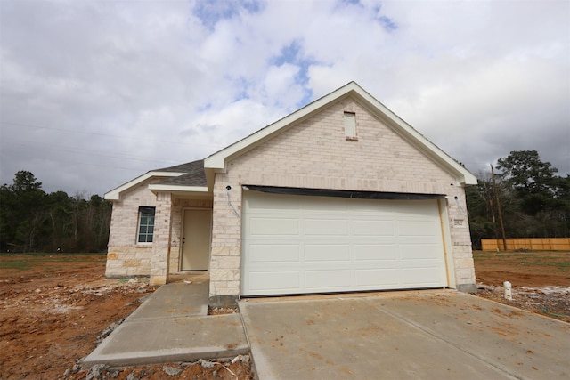 single story home featuring brick siding, driveway, and an attached garage