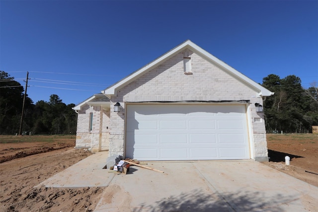 view of home's exterior with concrete driveway, brick siding, and an attached garage