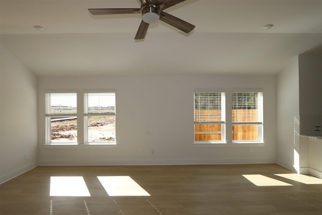 empty room featuring ceiling fan, wood finished floors, and baseboards