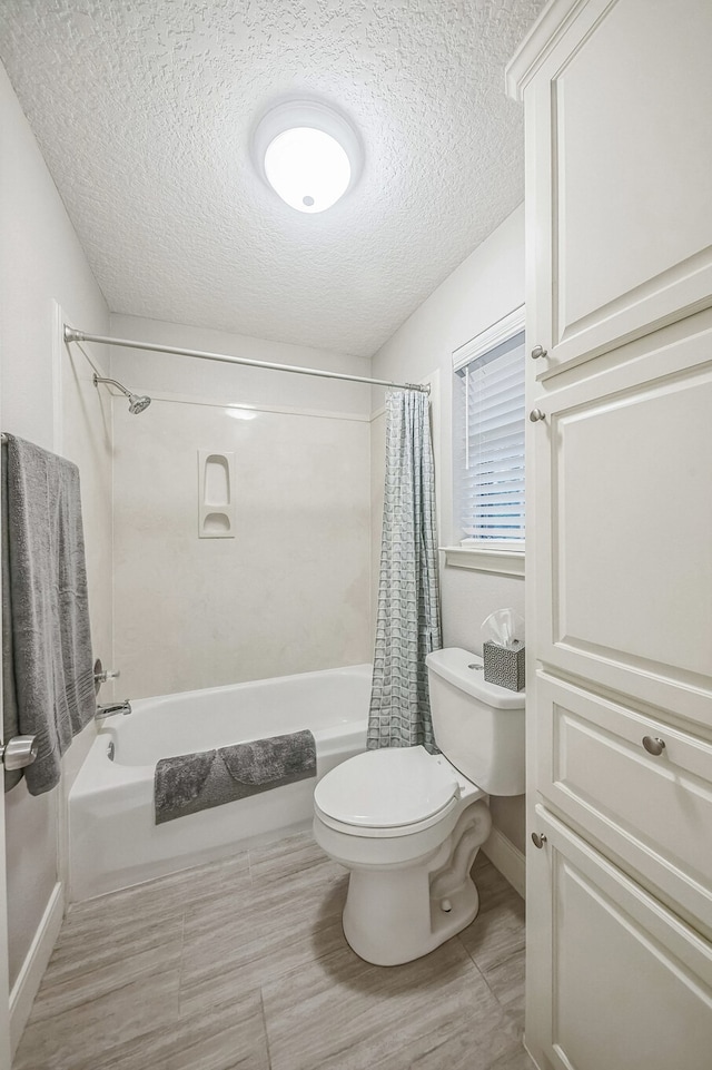 bathroom with toilet, a textured ceiling, and shower / tub combo