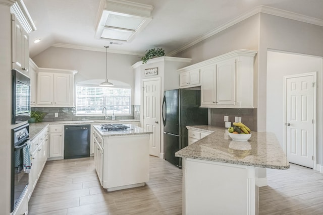 kitchen with white cabinets, a center island, a skylight, and black appliances