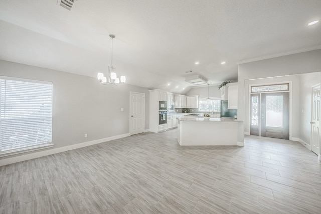 kitchen featuring white cabinetry, hanging light fixtures, lofted ceiling, and appliances with stainless steel finishes