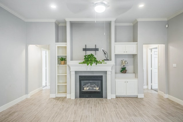 unfurnished living room featuring light wood-type flooring, ornamental molding, and a tiled fireplace