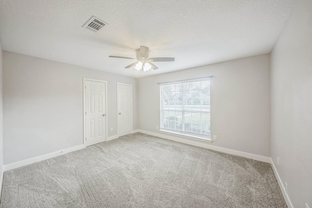 spare room with carpet, ceiling fan, and a textured ceiling