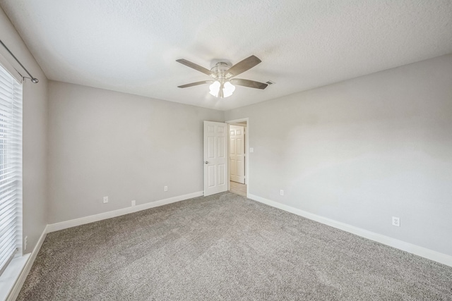 spare room featuring ceiling fan, carpet, and a textured ceiling