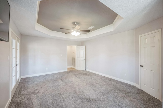 unfurnished bedroom featuring ceiling fan, french doors, a raised ceiling, carpet floors, and a textured ceiling