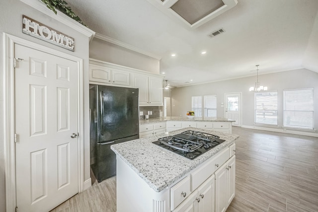 kitchen featuring a kitchen island, tasteful backsplash, light hardwood / wood-style flooring, white cabinets, and black appliances