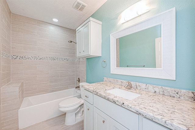 full bathroom with vanity, toilet, and tiled shower / bath combo