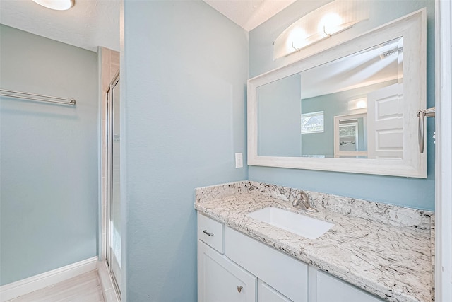 bathroom with vanity and a shower with shower door