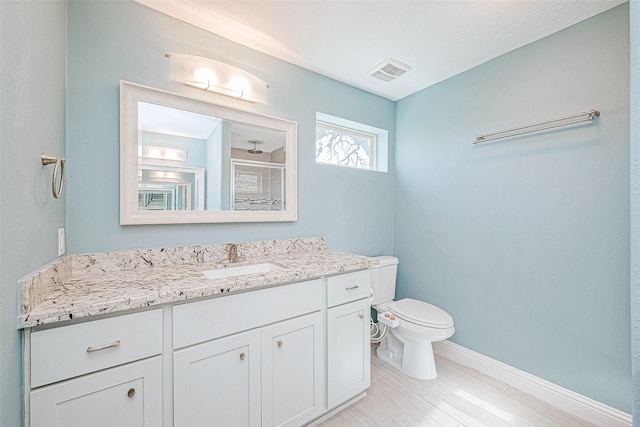 bathroom featuring toilet, vanity, and walk in shower