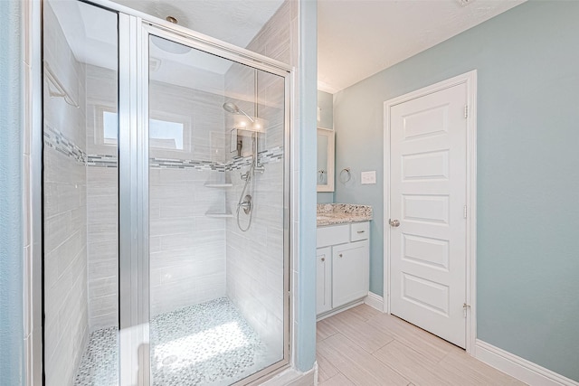 bathroom with vanity and a shower with door