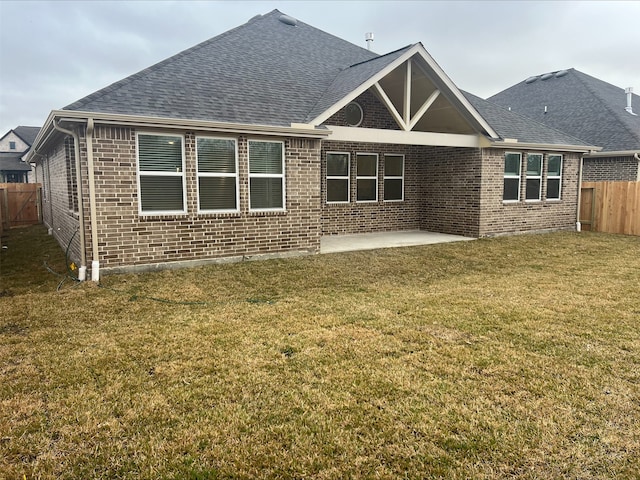 back of property with a lawn and a patio area