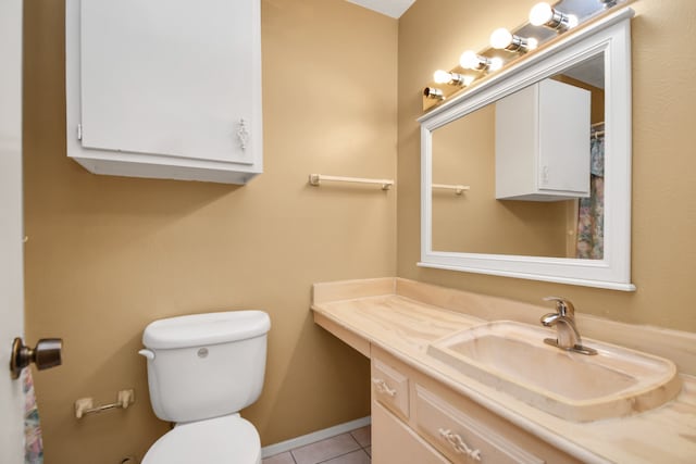 bathroom with tile patterned flooring, vanity, and toilet