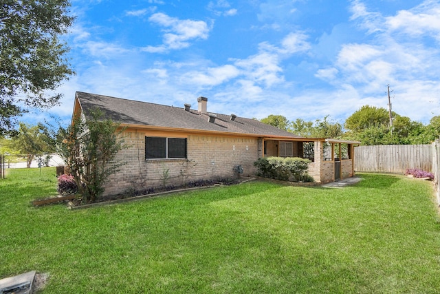 rear view of property with a lawn