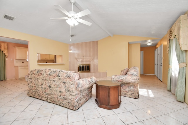 tiled living room featuring a tile fireplace, vaulted ceiling with beams, and ceiling fan