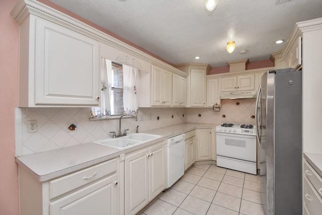 kitchen featuring decorative backsplash, light tile patterned floors, white appliances, and sink