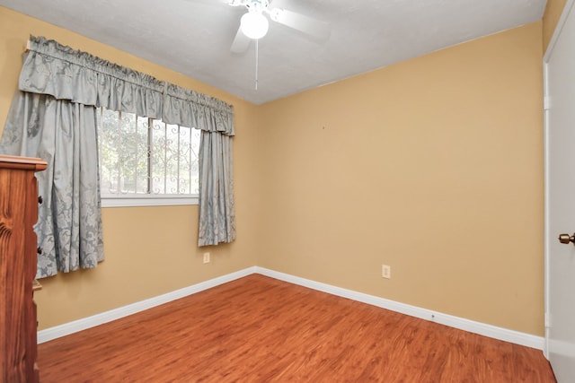 empty room with hardwood / wood-style floors and ceiling fan