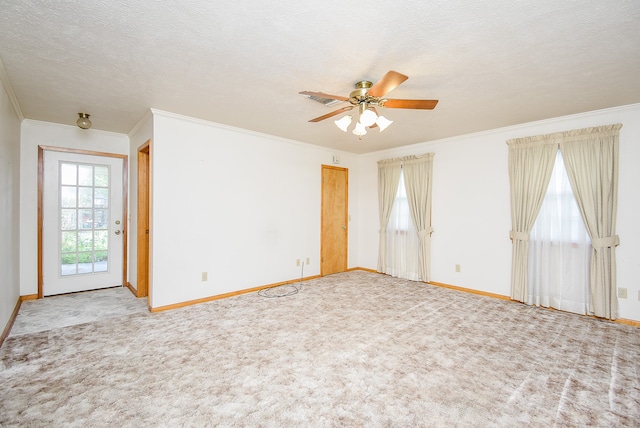 carpeted empty room featuring ceiling fan, a textured ceiling, and ornamental molding