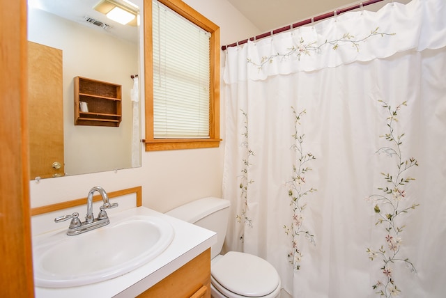 bathroom featuring vanity, toilet, and walk in shower