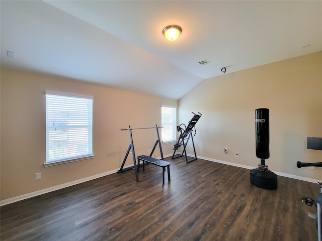 exercise room with vaulted ceiling and dark wood-type flooring