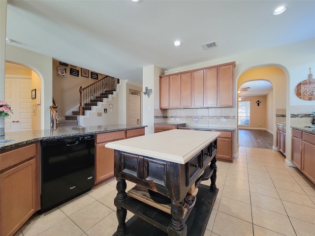 kitchen featuring ceiling fan, dishwasher, a kitchen island, and light tile patterned floors