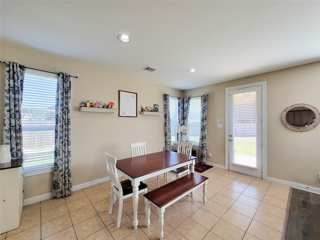 dining space with light tile patterned floors and a textured ceiling