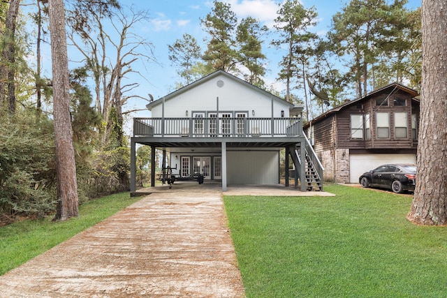 back of house featuring a garage, a wooden deck, and a lawn