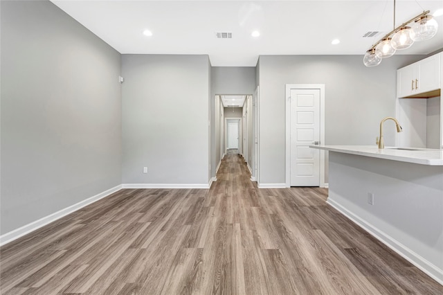 unfurnished living room with light hardwood / wood-style floors and sink