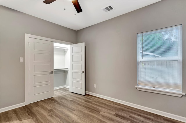 unfurnished bedroom with hardwood / wood-style floors, a closet, and ceiling fan