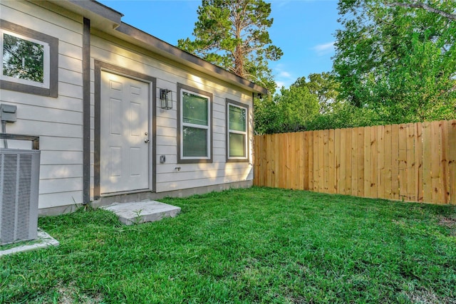 entrance to property with a yard and cooling unit