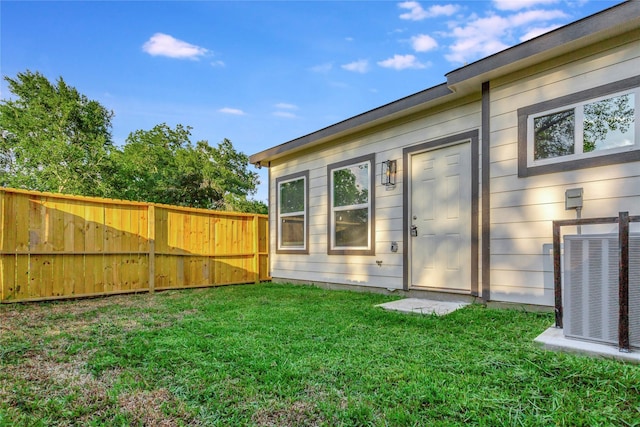 back of house with a lawn and central AC