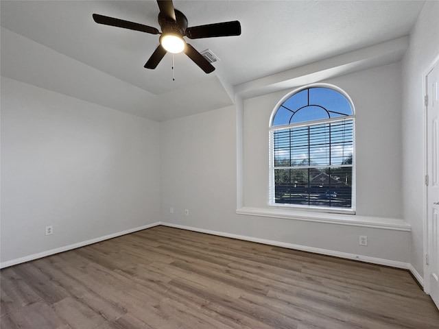 empty room with ceiling fan and light hardwood / wood-style flooring