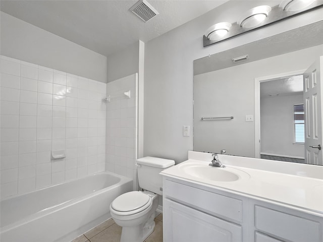 full bathroom featuring vanity, tile patterned flooring, tiled shower / bath combo, toilet, and a textured ceiling