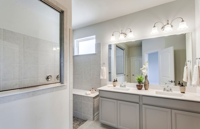 bathroom with vanity, a relaxing tiled tub, and tile patterned floors