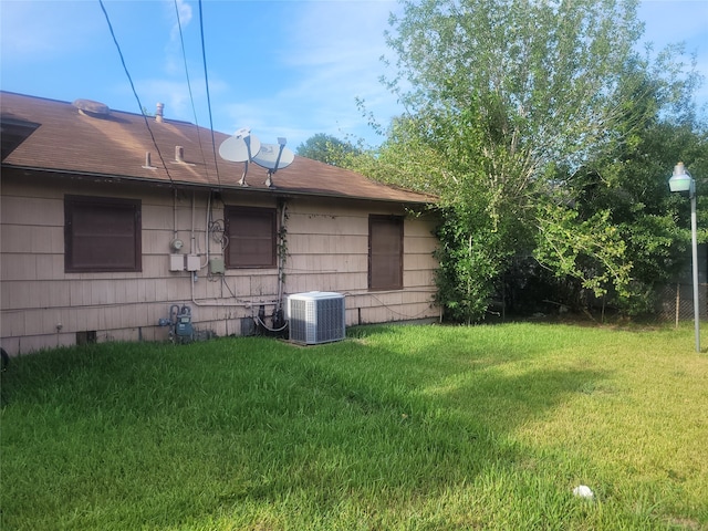 view of property exterior with a lawn and central AC unit