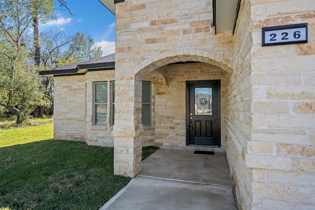 view of exterior entry with a lawn