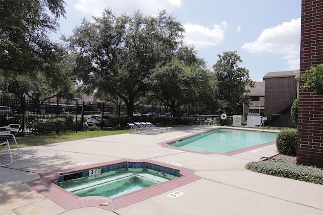 view of swimming pool with a patio area and a community hot tub