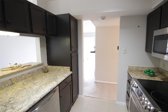 kitchen featuring light stone countertops, light tile patterned flooring, and appliances with stainless steel finishes