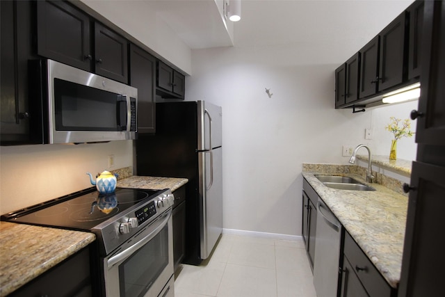 kitchen with sink, light stone countertops, stainless steel appliances, and light tile patterned floors