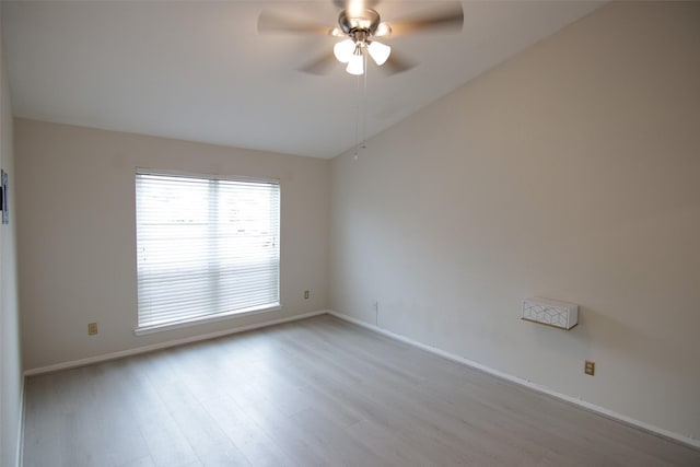 empty room featuring ceiling fan, light hardwood / wood-style flooring, and lofted ceiling