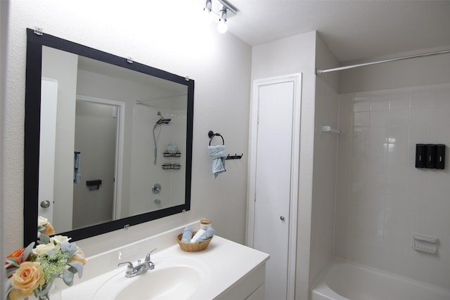 bathroom with vanity, tiled shower / bath combo, and a textured ceiling