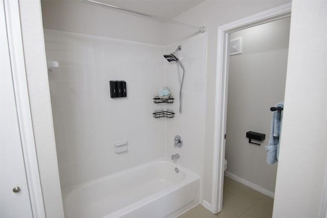 bathroom featuring tile patterned flooring, toilet, and tiled shower / bath