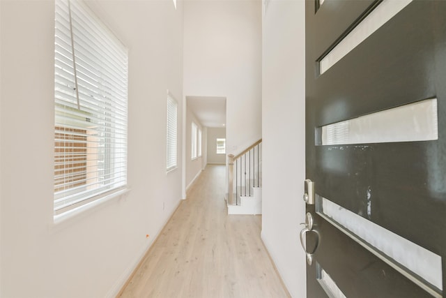 16334 Placid Stream St, Conroe, TX 77302 - hall with light wood-type flooring, baseboards, a high ceiling, and stairway