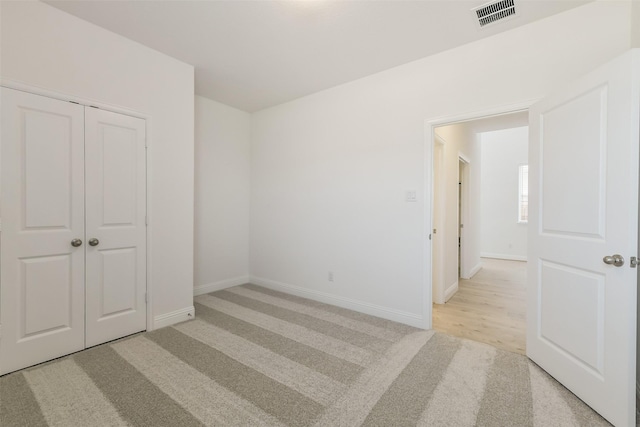 16334 Placid Stream St, Conroe, TX 77302 - unfurnished bedroom featuring light carpet, baseboards, visible vents, and a closet
