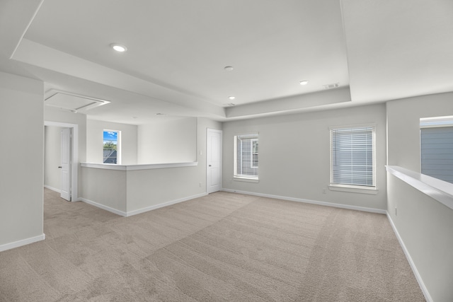 carpeted empty room featuring a tray ceiling