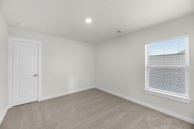 spare room featuring light colored carpet